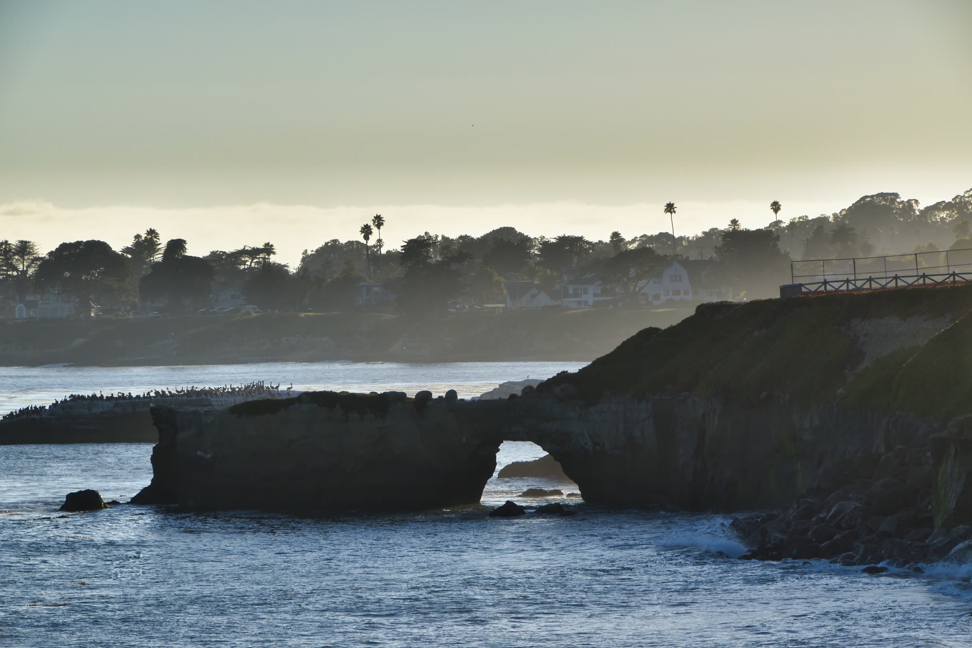 A natural rock arch along the Santa Cruz, California coastline at dusk