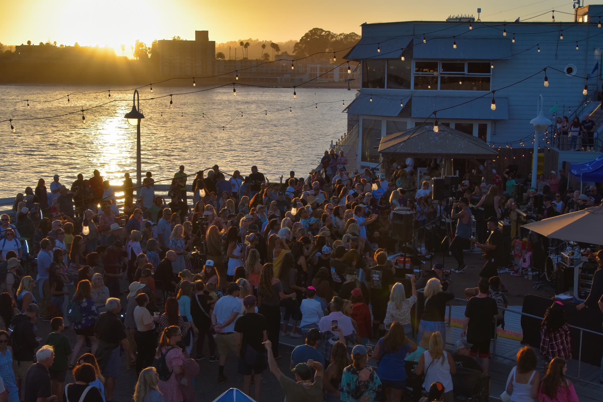 A crowd gathered at sunset for a live event on the Santa Cruz, California coast